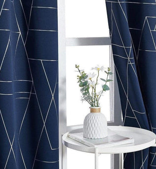 Rideaux élégants de couleur bleue avec motifs géométriques, parfaits pour apporter une touche moderne à votre intérieur. Idéal pour le salon ou la chambre, ce design raffiné s'adapte à divers styles de décoration. Le vase décoratif placé sur la table blanche ajoute une note de fraîcheur à l'ensemble de la pièce.