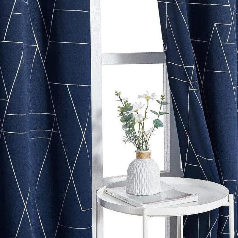 Rideaux élégants de couleur bleue avec motifs géométriques, parfaits pour apporter une touche moderne à votre intérieur. Idéal pour le salon ou la chambre, ce design raffiné s'adapte à divers styles de décoration. Le vase décoratif placé sur la table blanche ajoute une note de fraîcheur à l'ensemble de la pièce.