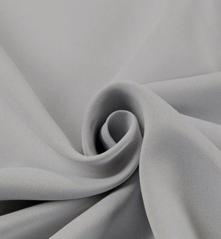 Tissu gris plié en spiral, idéal pour confection de vêtements et projets de couture, offrant une allure élégante et moderne pour toutes vos créations de mode.