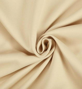 Tissu beige enroulé en spirale, idéal pour la confection de vêtements et décoration intérieure, offrant élégance et douceur visuelle. Parfait pour ajouter une touche de sophistication à vos projets artisanaux.