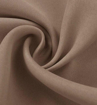 Tissu beige doux plié en spirale, idéal pour la confection de vêtements élégants et confortables, offrant un aspect raffiné et tendance pour toutes les saisons.