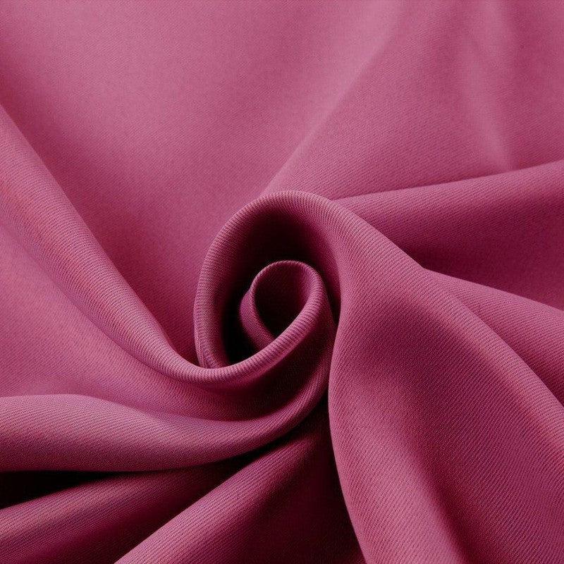 Tissu rose framboise drapé avec élégance, idéal pour des créations de couture tendance. Profitez de son allure chic pour vos projets de mode et décoration.