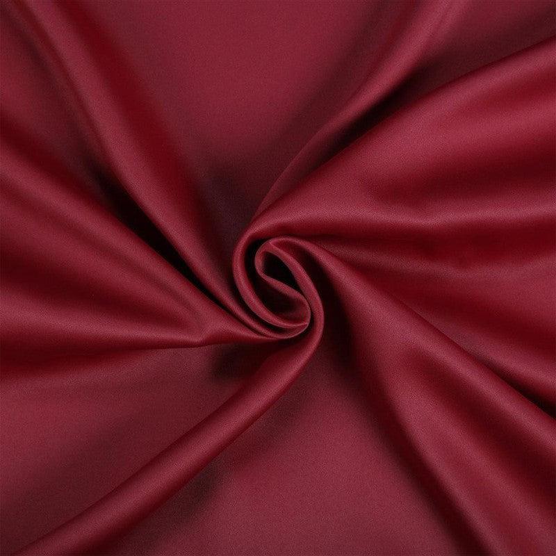 Étoffe rouge élégante avec drapé en spirale, idéal pour la décoration et l'habillement. Coloris riche et luxueux, parfait pour un design intérieur sophistiqué.