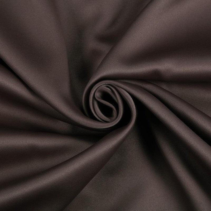 Tissu de couleur marron foncé, soigneusement enroulé, idéal pour la couture et la décoration intérieure. Ce textile est parfait pour apporter une touche d'élégance et de chaleur à votre intérieur.