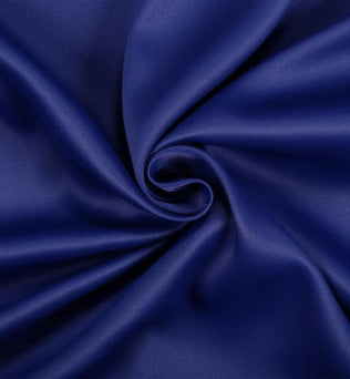 Image d'un tissu bleu vif, avec un drapé élégant formant un tourbillon au centre, idéal pour les projets de couture créatifs ou la décoration intérieure. Découvrez la richesse de sa couleur pour donner vie à vos idées de design.