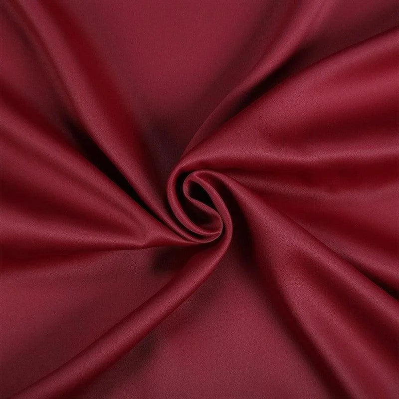 Étoffe rouge élégante avec drapé en spirale, idéal pour la décoration et l'habillement. Coloris riche et luxueux, parfait pour un design intérieur sophistiqué.