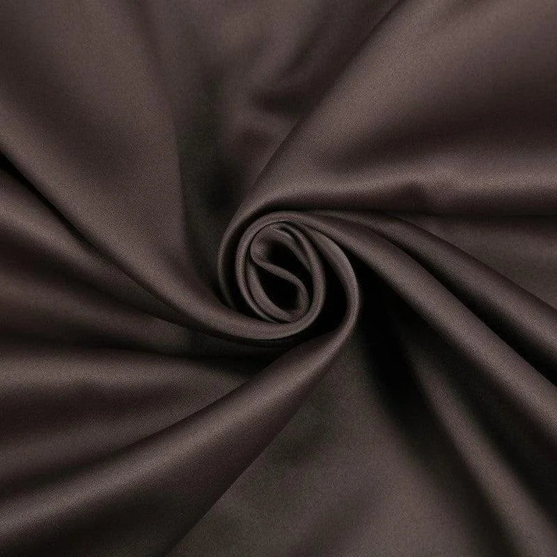 Tissu de couleur marron foncé, soigneusement enroulé, idéal pour la couture et la décoration intérieure. Ce textile est parfait pour apporter une touche d'élégance et de chaleur à votre intérieur.