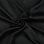 Image d'un tissu noir élégant, idéal pour la couture et la décoration. Ce tissu est parfait pour créer des vêtements sur mesure ou des projets de design intérieur moderne. La couleur noire profonde offre une base chic pour diverses applications créatives.