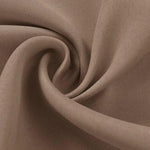 Tissu beige doux plié en spirale, idéal pour la confection de vêtements élégants et confortables, offrant un aspect raffiné et tendance pour toutes les saisons.