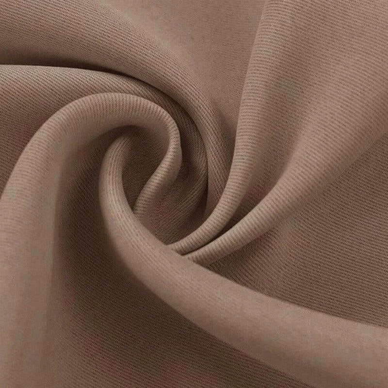 Tissu beige doux plié en spirale, idéal pour la confection de vêtements élégants et confortables, offrant un aspect raffiné et tendance pour toutes les saisons.