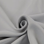 Tissu gris plié en spiral, idéal pour confection de vêtements et projets de couture, offrant une allure élégante et moderne pour toutes vos créations de mode.