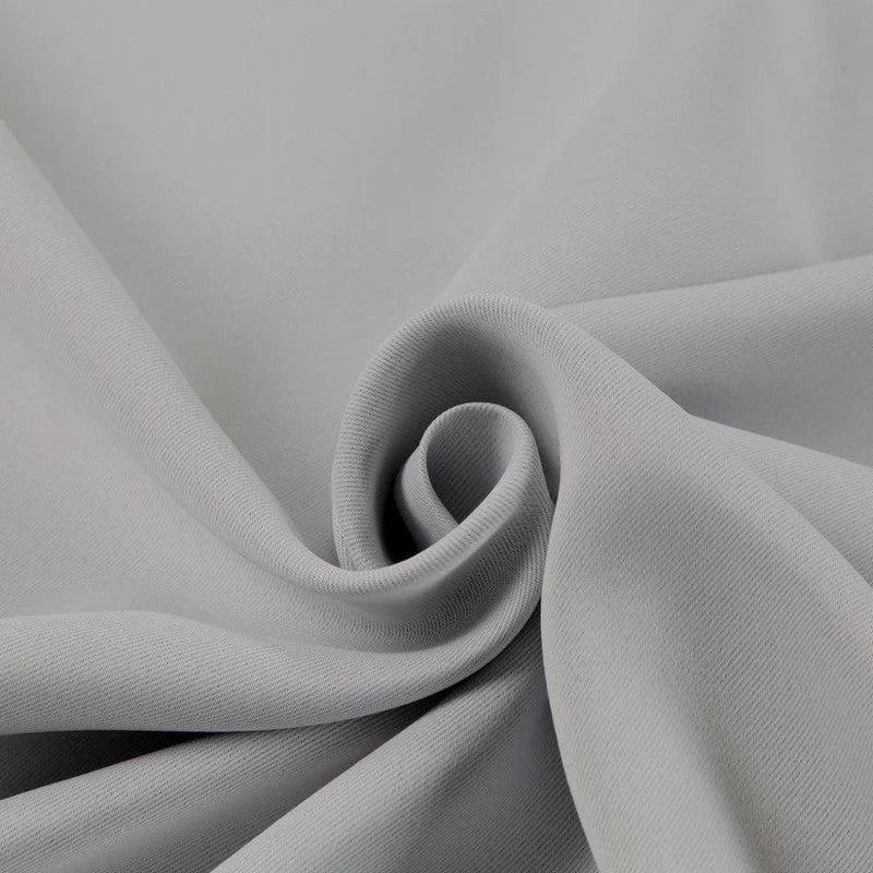 Tissu gris plié en spiral, idéal pour confection de vêtements et projets de couture, offrant une allure élégante et moderne pour toutes vos créations de mode.