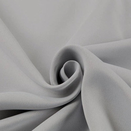 Tissu gris plié en spiral, idéal pour confection de vêtements et projets de couture, offrant une allure élégante et moderne pour toutes vos créations de mode.