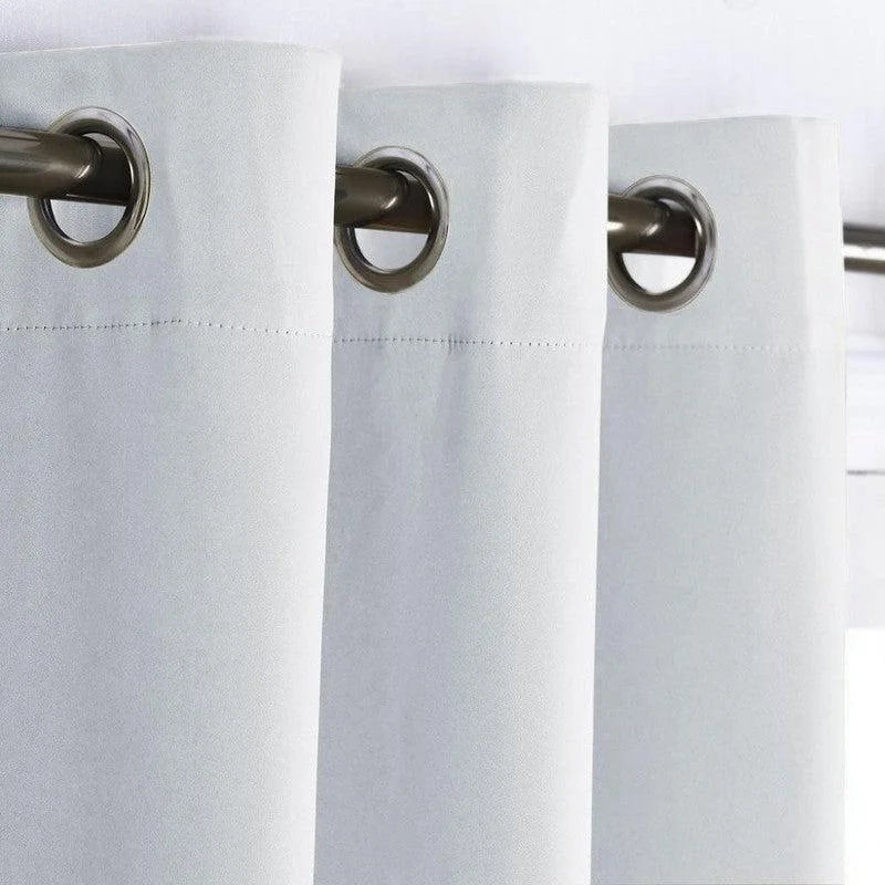 Rideaux blancs modernes avec œillets métalliques, parfaits pour une décoration intérieure élégante et lumineuse. Idéal pour un salon ou une chambre à coucher. Produit fonctionnel et esthétiquement plaisant.