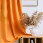 Rideau orange décoratif dans un intérieur moderne avec un vase blanc élégant et des herbes séchées, idéal pour ajouter une touche de couleur et de style naturel à votre salon ou chambre.