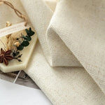 Image d'un élégant tissu beige accompagné d'un accessoire décoratif naturel, parfait pour ajouter une touche d'élégance à votre intérieur. Idéal pour les amateurs de design minimaliste et de décoration raffinée, cette composition visuelle met en valeur des détails subtils et des éléments décoratifs soigneusement sélectionnés.