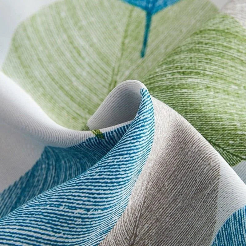 Rideau moderne avec motif de feuilles vertes et bleues sur fond blanc, idéal pour un salon ou une chambre. Tissu résistant et design naturel pour une décoration intérieure élégante et apaisante. Parfait pour ajouter une touche de nature à votre espace de vie.