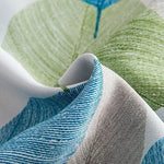 Rideau moderne avec motif de feuilles vertes et bleues sur fond blanc, idéal pour un salon ou une chambre. Tissu résistant et design naturel pour une décoration intérieure élégante et apaisante. Parfait pour ajouter une touche de nature à votre espace de vie.