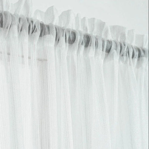 Voilage blanc délicat avec plis ondulés pour habillage de fenêtre, offrant une atmosphère lumineuse et élégante. Accessoire idéal pour une décoration intérieure moderne et épurée, parfait pour ajouter une touche de légèreté à n'importe quelle pièce.