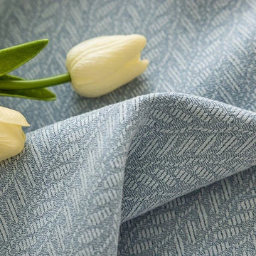 Tissu élégant avec motif à chevrons bleu clair, accompagné de tulipes blanches décoratives pour une touche de sophistication et de fraîcheur dans votre décoration intérieure. Idéal pour des rideaux ou des coussins, ce design intemporel apporte une ambiance apaisante et chic à n'importe quelle pièce. Parfait pour un style moderne et raffiné.