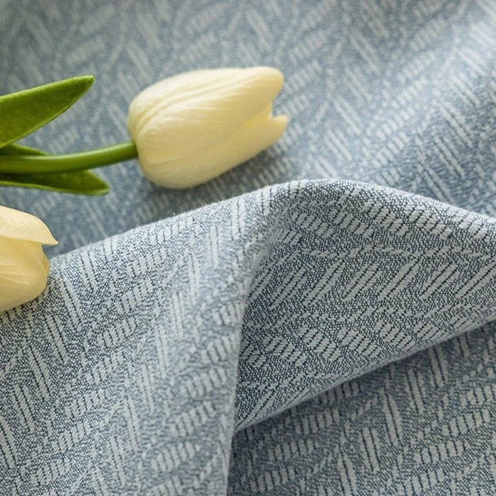 Tissu élégant avec motif à chevrons bleu clair, accompagné de tulipes blanches décoratives pour une touche de sophistication et de fraîcheur dans votre décoration intérieure. Idéal pour des rideaux ou des coussins, ce design intemporel apporte une ambiance apaisante et chic à n'importe quelle pièce. Parfait pour un style moderne et raffiné.