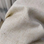 Gros plan d'un tissu beige, idéal pour la décoration intérieure élégante. Texture douce et agréable au toucher, convenant parfaitement pour des rideaux, coussins ou autres éléments de design. Apportez une touche de sophistication à votre espace avec cette étoffe intemporelle.