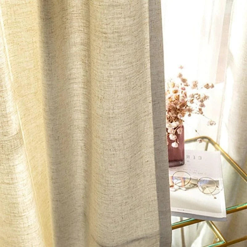 Rideau beige élégant laissant passer la lumière naturelle, idéal pour créer une ambiance chaleureuse dans votre intérieur. Accompagné de fleurs décoratives et d'une table en verre doré, parfait pour une décoration de salon contemporaine et apaisante.