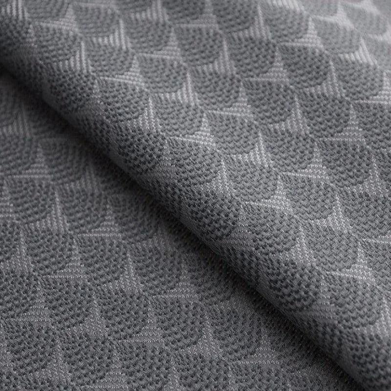 Texture de tissu gris avec motif géométrique en relief, idéale pour la décoration intérieure et le design de mode, ajoutant une touche d'élégance et de modernité à votre espace.