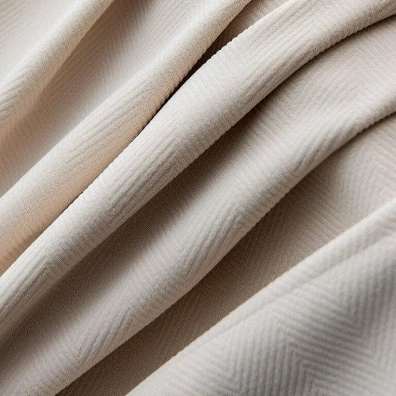 Drapé élégant de tissu beige avec motif subtil en chevrons, idéal pour la décoration intérieure et la confection de vêtements sophistiqués. Design raffiné et moderne, parfait pour ajouter une touche de charme à tout espace.