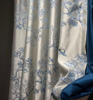 Rideau élégant avec motif de branches florales en bleu sur fond clair, accompagné d'une bande unie bleu foncé. Idéal pour ajouter une touche sophistiquée et naturelle à votre intérieur. Parfait pour le salon, la chambre ou la salle à manger, ce rideau offre une ambiance apaisante et raffinée à votre espace de vie.