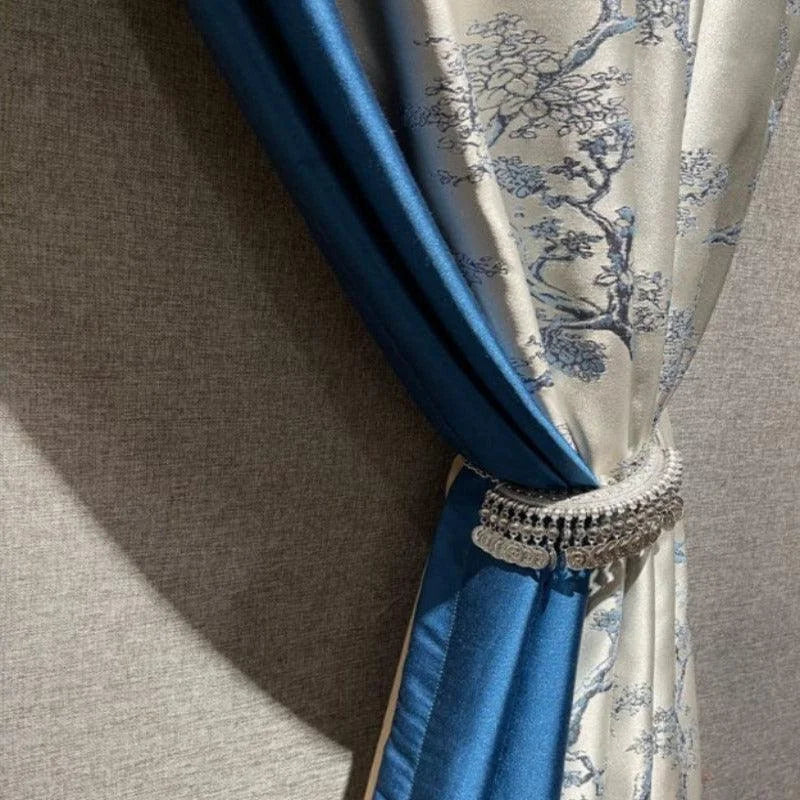 Rideau élégant bleu et gris avec motifs floraux, orné d'un embrasse décoratif, idéal pour ajouter une touche sophistiquée à votre intérieur. Parfait pour le salon ou la chambre, ce rideau crée une ambiance chic et raffinée.