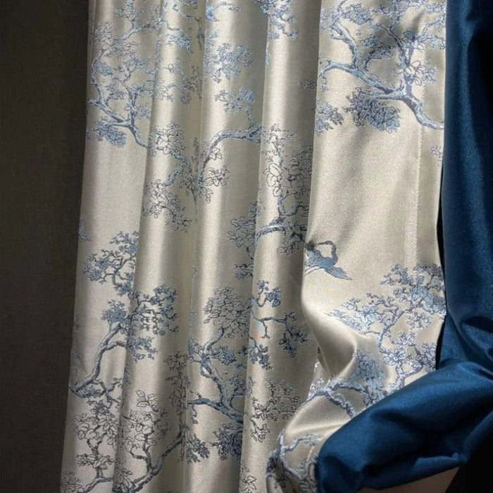 Rideau élégant avec motif de branches florales en bleu sur fond clair, accompagné d'une bande unie bleu foncé. Idéal pour ajouter une touche sophistiquée et naturelle à votre intérieur. Parfait pour le salon, la chambre ou la salle à manger, ce rideau offre une ambiance apaisante et raffinée à votre espace de vie.