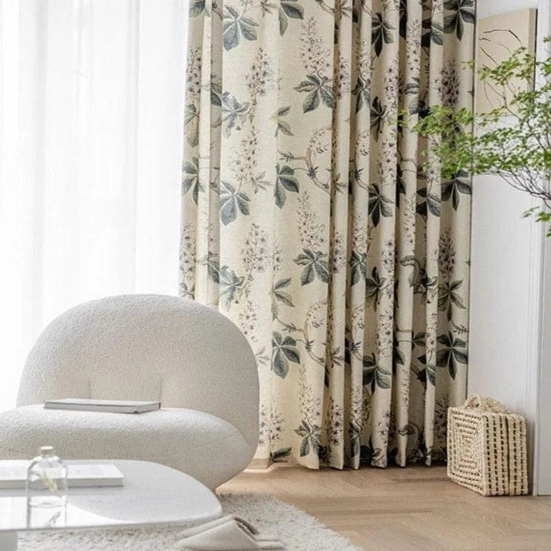 Fauteuil confortable de salon moderne devant un rideau à motif floral, créant une ambiance relaxante et naturelle. Idéal pour un intérieur contemporain avec une touche d'élégance. Décoration épurée mêlant style et confort.