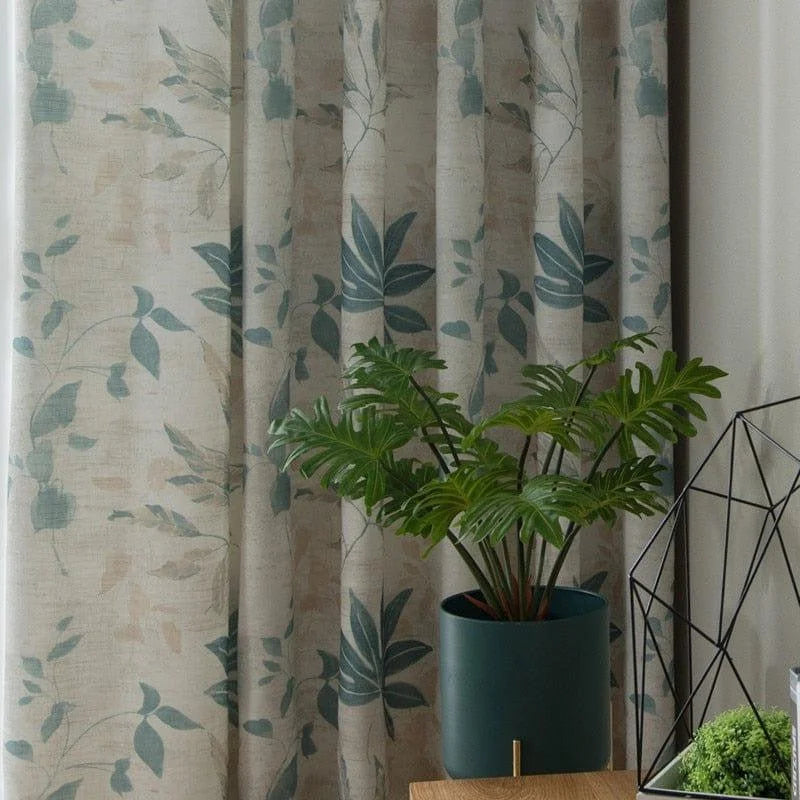 Rideau à motif floral bleu-vert, idéal pour une décoration intérieure moderne et élégante. Parfait pour ajouter une touche naturelle et apaisante à votre salon ou chambre à coucher. Accompagné d'une plante d'intérieur dans un pot contemporain, cette mise en scène apporte un charme intemporel et raffiné.