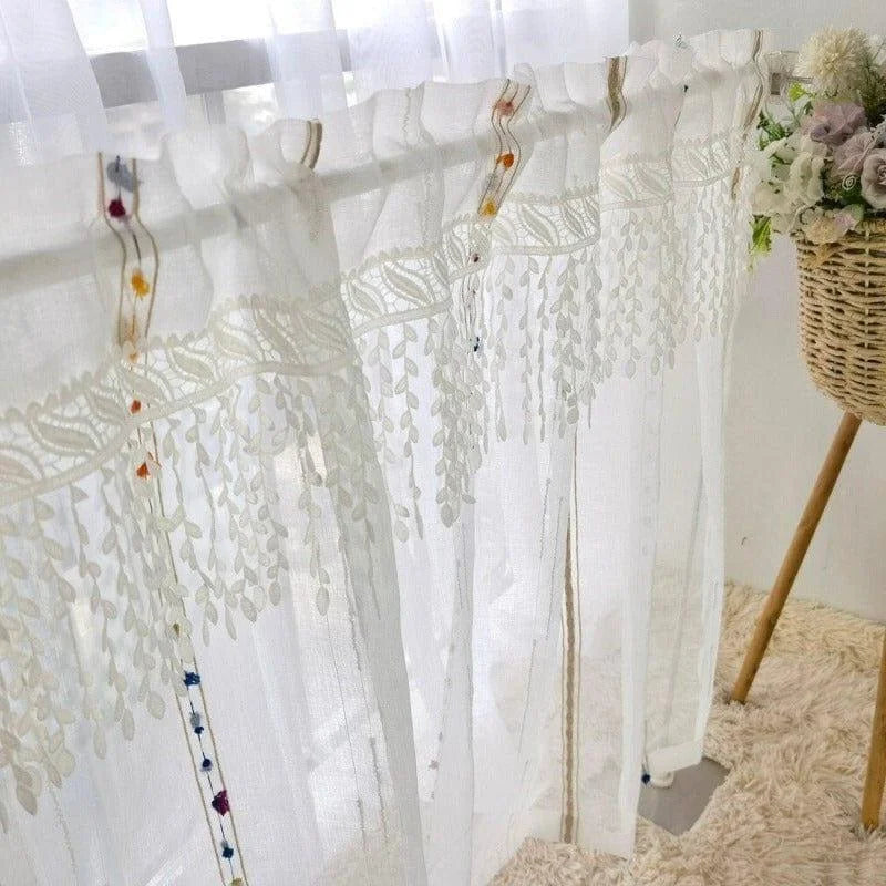 Rideaux décoratifs élégants suspendus à une fenêtre, ornés de motifs floraux délicats et de détails colorés, parfaits pour ajouter une touche de sophistication à tout intérieur. Atmosphère lumineuse et aérée, idéale pour les salons ou chambres modernes avec décoration florale.