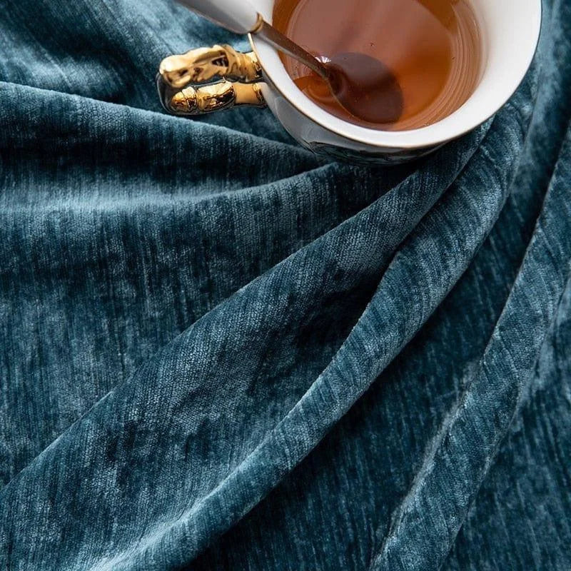 Tasse de thé élégante posée sur un tissu bleu raffiné, créant une ambiance chaleureuse et sophistiquée idéale pour la décoration intérieure. Parfait pour ajouter une touche de luxe à votre espace de vie.