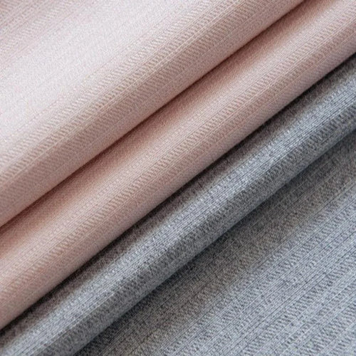 Tissus élégants dans des tons pastel roses et gris, parfaits pour la décoration intérieure ou la confection de vêtements, offrant une touche de douceur et de modernité à tout espace de vie.