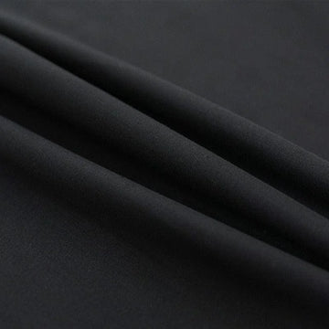 Image d’un tissu noir élégant, idéal pour confectionner des vêtements sur mesure. Ce textile offre une apparence sophistiquée, parfait pour des costumes ou des robes de soirée. Sa couleur sobre et intemporelle assure une allure chic et moderne.