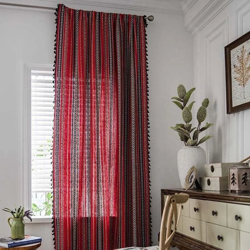 Rideau rouge à motifs géométriques noirs et blancs, suspendu dans un salon élégant. Ce rideau décoratif ajoute une touche de sophistication à la pièce, tout en filtrant délicatement la lumière naturelle. Idéal pour créer une ambiance chaleureuse et accueillante. Parfait pour les amateurs de décoration intérieure vintage ou moderne.