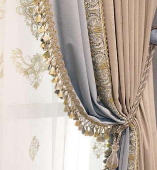 Rideau élégant avec broderies dorées et détails frangés. Idéal pour apporter une touche sophistiquée à votre intérieur. Accessoire parfait pour optimiser la décoration de votre salon ou chambre. Élément décoratif chic avec nuances beige et bleu, accentuant une ambiance classique et raffinée.