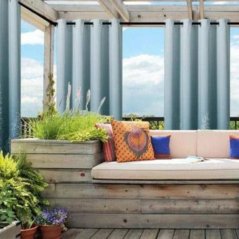 Salon de jardin moderne avec rideaux occultants, canapé confortable et coussins colorés, idéal pour créer un espace détente extérieur. Parfait pour profiter du plein air tout en préservant l’intimité. Aménagement extérieur avec plantes et pergola élégante.