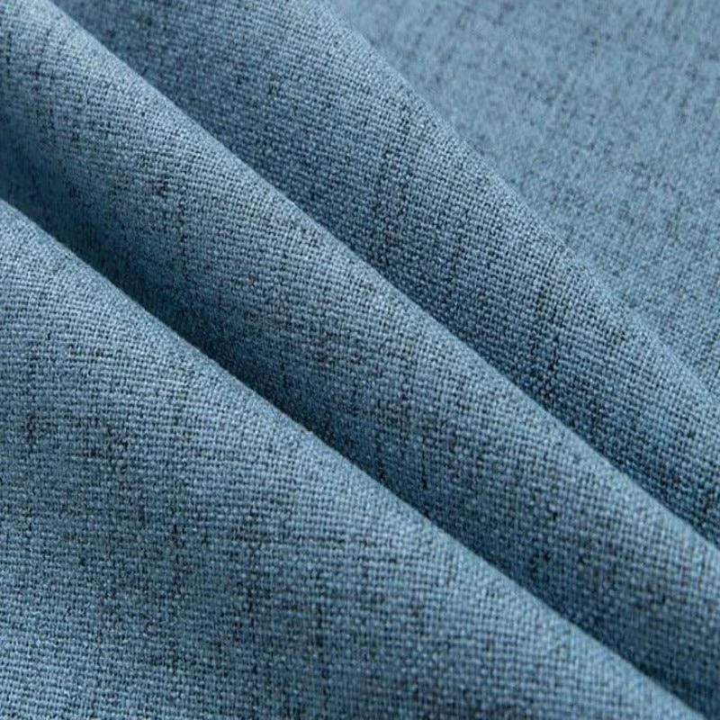 Image d'un textile bleu à motifs finement tissés, idéal pour la décoration intérieure, avec des plis mettant en valeur la texture du tissu. Parfait pour confectionner des rideaux, des housses de coussin ou des projets créatifs en design d'intérieur.