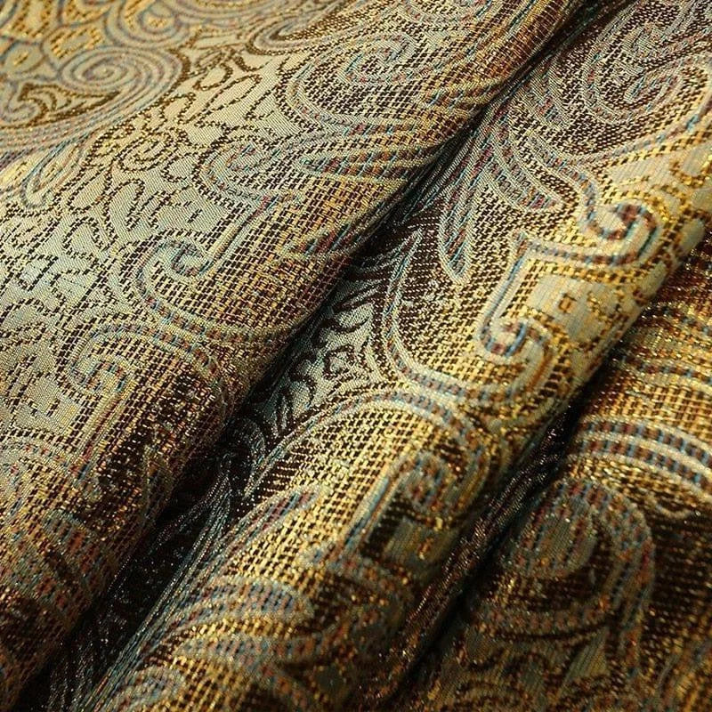 Tissu décoratif au motif complexe et élégant avec des motifs arabesques dorés et bleus, idéal pour la décoration intérieure, les tentures ou les coussins. Design riche en détails pour une ambiance sophistiquée et luxueuse.