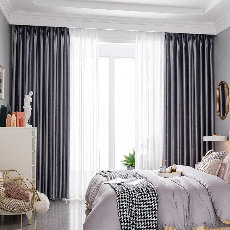 Chambre élégante avec rideaux occultants gris, offrant une ambiance moderne et sophistiquée. Design harmonieux avec un lit douillet et des éléments décoratifs chics pour un intérieur accueillant et lumineux. Idéal pour optimiser le confort et l'intimité tout en ajoutant une touche de style à la pièce.