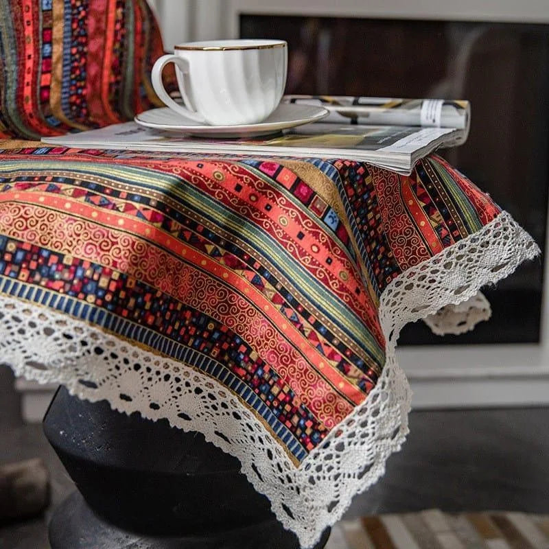 Nappe bohème colorée aux motifs géométriques et bordure décorative, parfaite pour apporter une touche d'élégance à votre décoration intérieure. Complément idéal pour un coin café cosy, mise en valeur avec une tasse de thé posée sur un magazine, pour une ambiance chaleureuse et accueillante. Parfaite pour les tables de salon ou de cuisine, cette nappe rehausse l'esthétique de votre espace avec son design vibrant et stylisé.