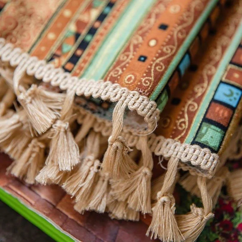 Gros plan sur un tapis décoratif coloré avec des motifs géométriques et des franges élégantes. Idéal pour ajouter une touche de chaleur et de style à votre intérieur. Parfait pour le salon ou la chambre, ce tapis apportera une ambiance accueillante à votre espace.