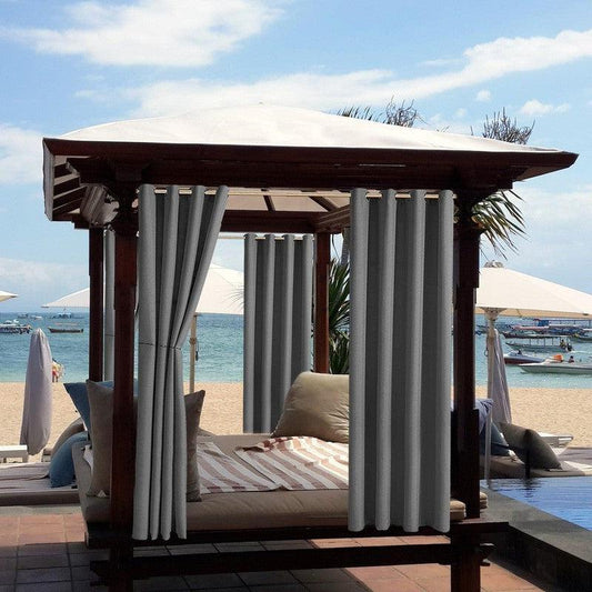 Cabane de plage élégante avec rideaux gris et toit blanc, offrant un espace de détente confortable au bord de la mer. Idéale pour se relaxer à l'ombre tout en profitant de la vue sur l'océan. Parfaite pour des moments de tranquillité en plein air, cette structure ajoute une touche de luxe à toute expérience balnéaire.