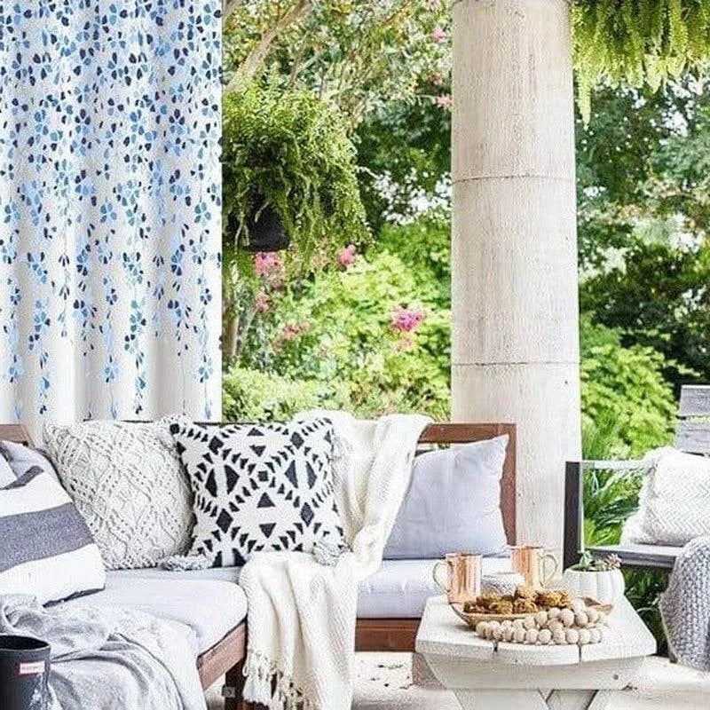 Salon de jardin élégant avec coussins décoratifs et table basse, entouré de verdure luxuriante. Espace extérieur invitant pour des moments de détente en plein air. Ambiance confortable et accueillante idéale pour profiter du jardin.