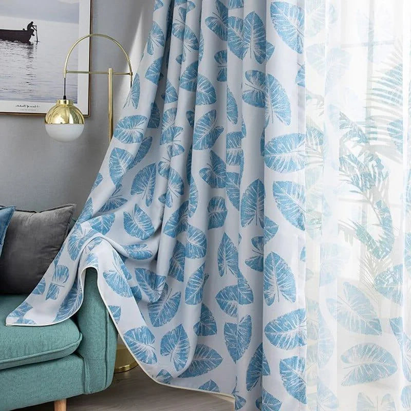 Rideaux élégants à motifs de feuilles bleues pour une décoration intérieure moderne. Idéaux pour ajouter une touche de fraîcheur et de style dans le salon ou la chambre. S'harmonisent parfaitement avec un canapé bleu et un éclairage contemporain.