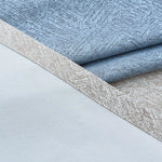 Image de tissus superposés, présentant un motif texturé en bleu et beige, idéal pour la décoration intérieure et l'ameublement. Parfait pour ajouter une touche élégante et contemporaine à vos projets de design d'intérieur.